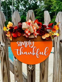 a wooden sign that says simply grateful on the side of a fence next to a pool