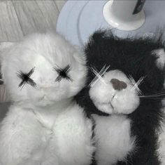 two black and white stuffed animals sitting next to each other