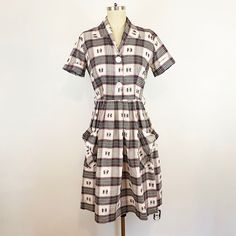 "Adorable 1940s cotton plaid day dress. 100% cotton in a sweet gray, red, and yellow plaid on a white background. Collared neckline, short sleeves, darted bust, large white button front to waist. A-line skirt with large skirt pockets. Unlined and no makers label, made circa late 1940s. In beautiful vintage condition, hand washed, no flaws to note, ready to wear.  Measurements Estimated modern women's size Small 4 Shoulder to Shoulder 15\" Shoulder to Sleeve Cuff 8\" Bust 38\" Waist 26\" Hip 48\" Length Shoulder to Waist 16.5\" Length Waist to Skirt Hem 24.5\" Skirt Sweep Across 30\" All items are pre-owned and show signs of wear or age, any large flaws or repairs are listed. Please read shop policies before purchasing for information on returns, sizing, shipping, etc. Also feel free to dir Vintage Plaid Dress For Work, Retro Cotton Plaid Dress For Picnic, White Fitted Plaid Dress For Daywear, Cotton Plaid Dress With Buttons For Daywear, White Cotton Plaid Dress With Short Sleeves, Classic Cotton Plaid Dress, Retro Plaid Dress For Daywear, Classic Plaid Cotton Dress, Classic Short Sleeve Plaid Dress