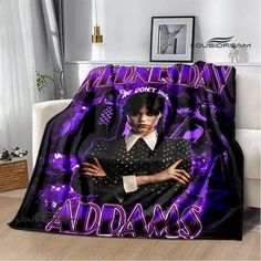 a woman with her arms crossed under a purple and black blanket