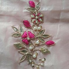 a close up of a piece of cloth with flowers and pearls on the back of it