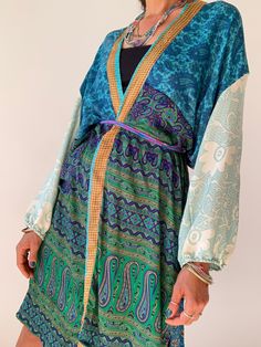 "This is silk puff sleeve kimono with the most gorgeous flow,  it's puffed sleeve that adds style, the belt is removable, and this item is so versatile.  This one has simple ethnic style print  can be paired up with jeans and t.shirt for a more casual look,  or dress it up with some smart trousers, wear it on the beach, spa or to a dinner party the choice is really yours MEASURE ONE SIZE Medium  Recommended for UK size 8-12 Length approx. 45\" MATERIAL *polyester * no lining  NOTE Please note co Silk Long Kimono For Beach Cover-up, Blue Kimono With Tie Waist, Blue Kimono With Tie Waist And Kimono Sleeves, Silk Wrap Kimono For Vacation, Silk Kimono With Kimono Sleeves For Beach Cover-up, Silk Beachwear Kimono With Kimono Sleeves, Summer Silk Kimono With Tie Waist, Flowy Silk Long Sleeve Kimono, Bohemian Wrap Robe With Tie Waist