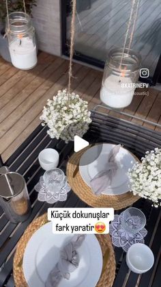 the table is set with white flowers and plates