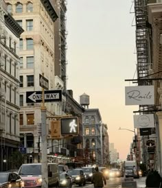 a city street filled with traffic next to tall buildings