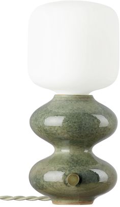 a green table lamp with a white light on it's side and a cord attached to the base