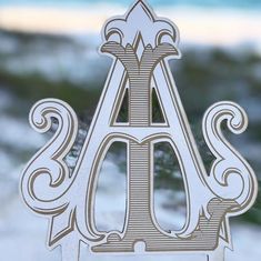 the letter a is made out of wood and has an intricate design on it's side