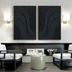 two black and white paintings hanging on the wall in a living room with modern furniture