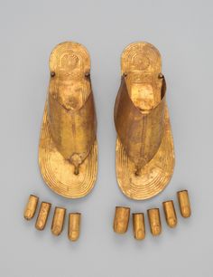 two gold sandals and five small wooden pegs