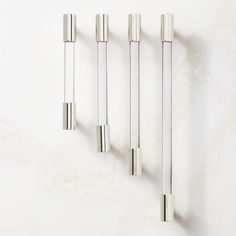 four stainless steel handles on a white wall