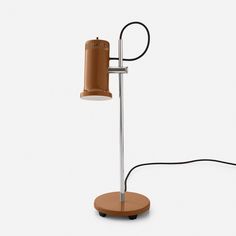 a lamp that is on top of a wooden stand with a cord attached to it