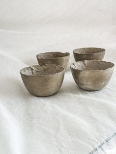 three bowls sitting on top of a white table cloth