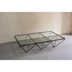 a glass and metal coffee table on concrete floor