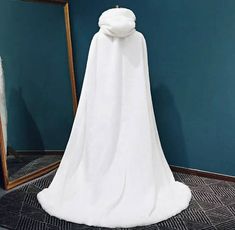 a white cloak on display in front of a mirror