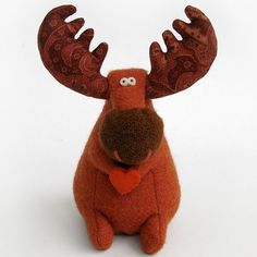 a red stuffed animal with large antlers on it's head and eyes, sitting in front of a white background