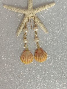 Hawaiian sunrise sea shell gold plated wire wrapped earrings with white fresh water pearls. The earring hooks are gold filled and nickel free. The drop length is 2.5 inches. This exact pair of earrings may have been sold but a pair can be made in this style that is just as beautiful. These rare Hawaiian sunrise sea shells represent the gorgeous sunrises of the Hawaiian Islands. This makes an especially fine keepsake gift for a loved one! Beach Pearl Drop Earrings, Summer Gold Shell-shaped Pearl Earrings, Summer Gold Dangle Pearl Earrings, Summer Gold Pearl Drop Earrings, Gold Dangle Pearl Earrings For Summer, Gold Pearl Drop Earrings For Summer, Ocean-inspired Gold Pearl Earrings For Beach, Gold Shell Pearl Charm Earrings, Gold Shell Pearl Dangle Earrings