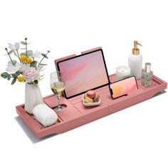 a pink tray with flowers and other items on it