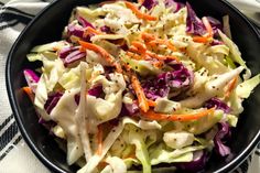 a black bowl filled with coleslaw and carrots