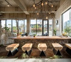 an indoor dining area with wooden benches and large windows