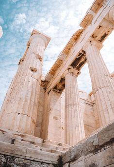 an old building with two columns on the side and sky in the backround