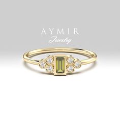 a yellow gold ring with an emerald stone and diamonds on the side, in front of a