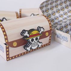 a wooden box with a pirate skull and crossbones on the front, sitting next to another box