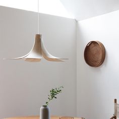 a white room with two hanging lights and a plant on the table next to it