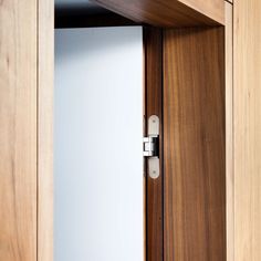 an open wooden door with a white wall in the background and wood trim around it