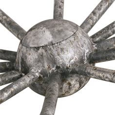 a metal object that looks like a spider's legs and head with holes in the middle