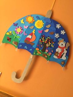 an umbrella is hanging on the wall with magnets and paper cutouts to decorate it