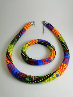 multicolored beaded necklace and bracelet set on white surface with metal clasps