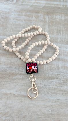 Teach Love Inspire! These wooden bead lanyards are everything! Cute, unique, and so versatile it'll pair great with any outfit. These happy vibes lanyards are sure to inspire a fun day of learning!  Perfect teacher gift 🍎Best Teacher Ever! This listing is for ONE lanyard.   ☾ All holders are made at a drop of approximately 20-22 inches. Please see pictures for reference. If special sizing is needed please let me know.  ☾ Made with quality materials. I take time to look for and select the best q Wooden Bead Lanyard, Teacher Badge Holder, Teacher Badge, Teach Love Inspire, Lanyard Keychain, Best Teacher Ever, Beaded Lanyards, Happy Vibes, Wristlet Keychain