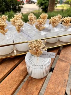 small vases with dried flowers in them on a wooden table