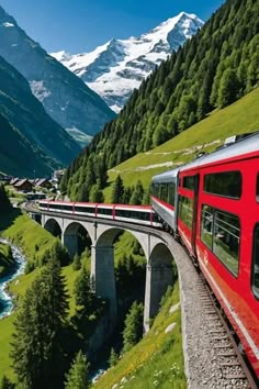 a red train traveling over a bridge in the mountains