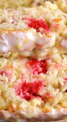 a close up view of a cake with icing and strawberries on it's crust