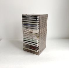 a stack of cd's sitting on top of each other in front of a white wall