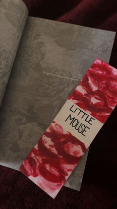 an open book with the title little mouse written on it and red roses painted on paper