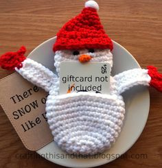 a crocheted snowman ornament on a plate with a tag that says, there is giftcard not included