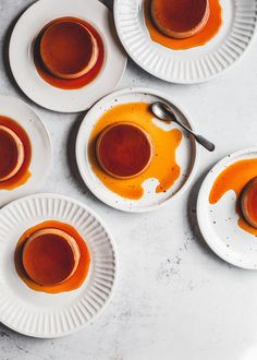 four white plates filled with sauce on top of a table