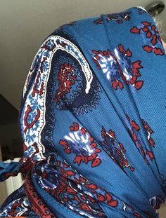 the back of a woman's head wearing a blue dress with red, white and blue designs