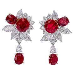 A classic bouquet pigeon blood ruby and diamond earrings, each with a three ruby symphony. Certified by GRS (Gem Research Swisslab) as pigeon blood for the fiery hue radiating from the ruby. This unique design will become a go-to for your jewelry collection and is sure to bring you endless compliments ! Mounted in 18k white gold. The two center rubies weigh 1.42 and 1.21 ct each. They are both certified by GRS, stating that they are Burmese, no heat, pigeon blood. The remaining 4 rubies have a weight of 2.78 ct. The earrings have a total weight 5.41 ct of ruby. There are also a mix of round, pear, and marquise shaped diamonds in this pair of earrings. They weigh a total of 2.74 ct and are made up of 22 pieces. Ruby Jewelry Design, Classic Bouquet, Ruby And Diamond Earrings, Blood Ruby, Marquise Shape Diamond, High Jewellery, Dreamy Room, Expensive Jewelry, Ruby Earrings