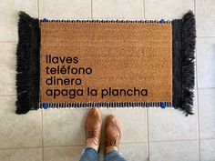 a person standing in front of a door mat that says, i always telefono dinero apaga la placha