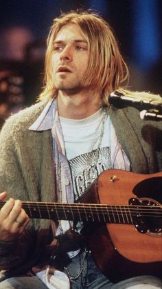 a man holding a guitar with a red heart on it