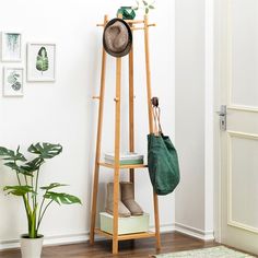 a wooden shelf with a hat and bag on it next to a potted plant