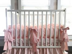 a baby crib with pink and white bedding