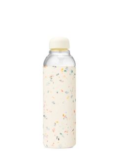 a white bottle with sprinkles on the side and a yellow cap is shown