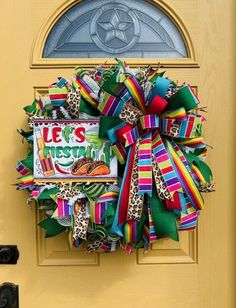 a yellow door with a colorful wreath on it