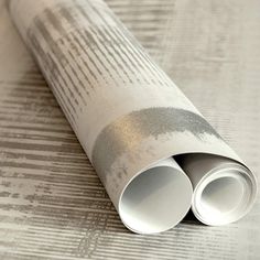 a rolled up wallpaper with metallic foil on it's edges and two tubes sticking out