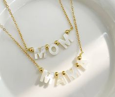 Whether it's MOM or MAMA, whatever you call her, these 14k gold plated necklaces are a perfect gift to say I Love You this Mother's Day, or any day. Cheap Pink Charm Necklaces For Mother's Day, White Charm Necklaces For Mother's Day Gift, White Charm Necklace For Mother's Day Gift, White Pendant Necklaces For Mother's Day, White Jewelry For Mother's Day, White Pendant Necklace For Mother's Day, Mother's Day Gold Name Necklace With Clavicle Chain, Dainty White Name Necklace For Mother's Day, Adjustable White Necklace - Gift For Mom