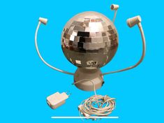 a silver disco ball with headphones and wires attached to it, on a blue background