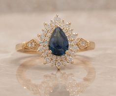 a blue and white diamond ring sitting on top of a table